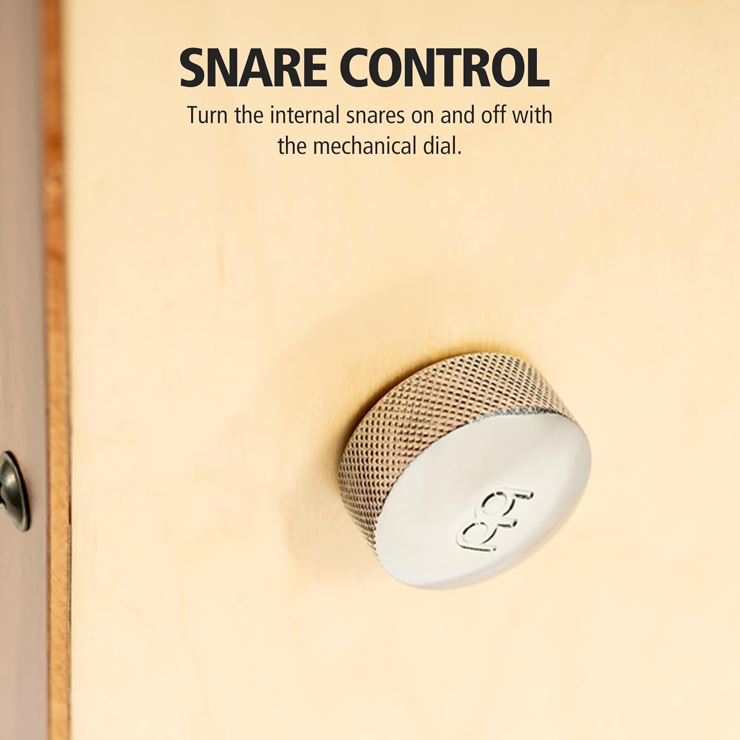 Close no botão metálico texturizado de controle mecânico do snare em cajon Meinl Snarecraft Professional.