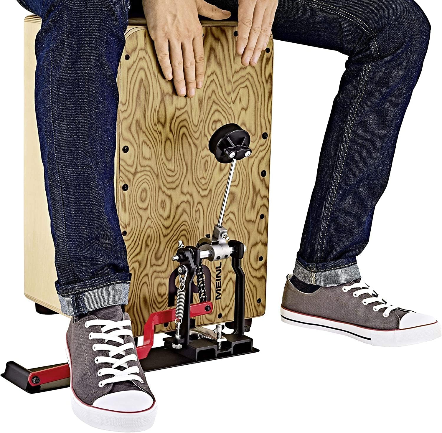 Pessoa utilizando pedal Meinl para cajon, ativado pelo calcanhar, encaixado em cajon de madeira clara